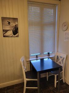 una sala da pranzo con tavolo, sedie e una finestra di 3 roms leilighet Narvik sentrum a Narvik