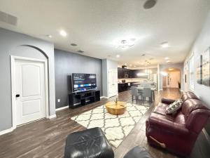 ein Wohnzimmer mit Ledercouch und Fernseher in der Unterkunft Orlando Dream Escape in Saint Cloud