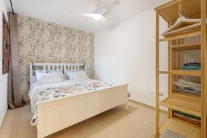 a bedroom with a white bed and a shelf at Feel The Sun In Tenerife in Costa Del Silencio