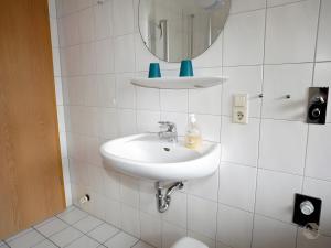 a white bathroom with a sink and a mirror at Scharbachhof in Glottertal