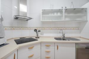 a kitchen with white cabinets and a sink at Feel The Sun In Tenerife in Costa Del Silencio +21 photos