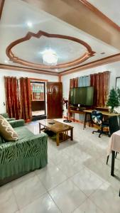 ein Wohnzimmer mit Couch und Flachbildfernseher in der Unterkunft Len Staycation in Panabo 3BDR-2BR-Downstairs Wifi Netflix in Panabo