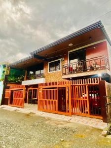 ein Haus mit einem orangenen Zaun davor in der Unterkunft Len Staycation in Panabo 3BDR-2BR-Downstairs Wifi Netflix in Panabo