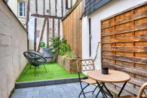 eine kleine Terrasse mit 2 Stühlen und einem Tisch in der Unterkunft Le Nid Vouté charmant appartement avec terrasse situé au coeur de Rouen in Rouen