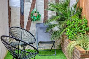 eine Terrasse mit zwei Stühlen und Pflanzen im Hof in der Unterkunft Le Nid Vouté charmant appartement avec terrasse situé au coeur de Rouen in Rouen