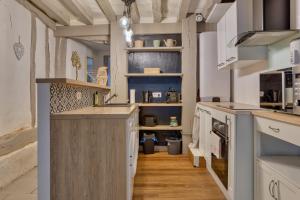 eine Küche mit einer großen Insel in einem Zimmer in der Unterkunft Le Nid Vouté charmant appartement avec terrasse situé au coeur de Rouen in Rouen + 22 Fotos