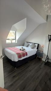une chambre avec un grand lit dans un grenier dans l'établissement LARGE 3 BEDROOM HOME, 3 BATHROOMS, FREE PARKING, FAST WIFI, à Belfast