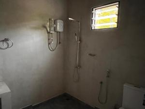 Un baño con ducha, inodoro y ventana. en BigJ Villas - Nilaveli, en Nilaveli