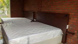 2 camas sentadas junto a una pared de ladrillo en BigJ Villas - Nilaveli, en Nilaveli