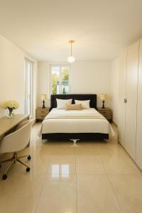 een slaapkamer met een groot bed, een bureau en een stoel bij Luxury Mosel Panorama Apartment in Koblenz