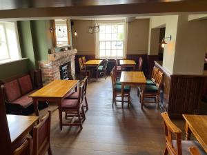 a restaurant with tables and chairs and a fireplace at The Swan Hotel and Public House in East Ilsley +3 photos