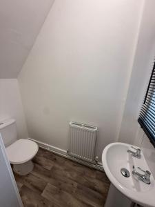 ein weißes Badezimmer mit Toilette und Waschbecken in der Unterkunft Station House in Scunthorpe