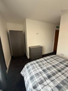 ein leeres Zimmer mit einem Bett und einer Kommode in der Unterkunft Station House in Scunthorpe