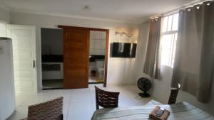 a living room with a table and chairs and a window at Pousada bandeirantes in Ilhéus