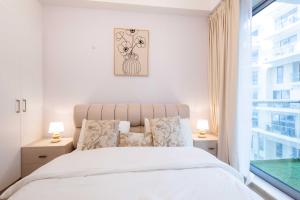 ein weißes Schlafzimmer mit einem Bett und einem Fenster in der Unterkunft Island Bliss 2 BR with Private Beach and Pool in Al Marjan Island in Ras al Khaimah + 28 Fotos