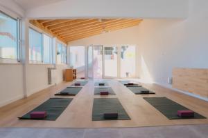 ein Yogaraum mit einer Reihe von Yogamatten in der Unterkunft Surf Lodge Santa Cruz in Silveira