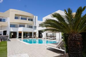 a villa with a swimming pool and a palm tree at Faedra Beach in Agios Nikolaos