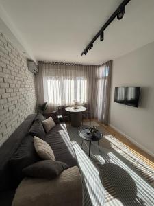 a living room with a couch and a brick wall at Urban Nest Belgrade in Belgrade