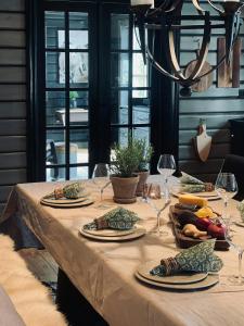 ein Tisch mit Tellern mit Essen und Weingläsern in der Unterkunft Spacious Family Cabin In Western Golsfjellet in Gol