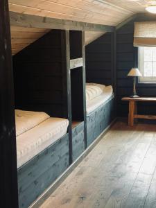 2 Etagenbetten in einem Zimmer mit einem Tisch in der Unterkunft Spacious Family Cabin In Western Golsfjellet in Gol