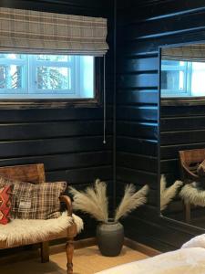 ein Schlafzimmer mit schwarzen Wänden und einem Stuhl und einer Pflanze in der Unterkunft Spacious Family Cabin In Western Golsfjellet in Gol