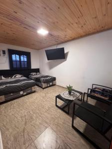 a room with two beds and a tv on the wall at La morada del Norte in Roque Sáenz Peña