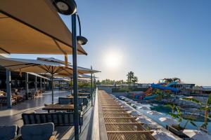 a patio with tables and chairs and a water park at Sentido Luna Vista Belek Hotel in Belek