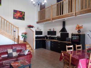 un salon avec un canapé rouge et une table dans l'établissement Gîte Braunis 4 étoiles, à Bourran