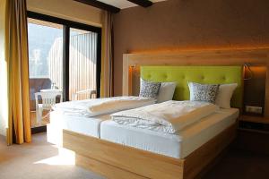 Un dormitorio con una cama grande con cabecero verde. en Hotel Sewenig, en Müden