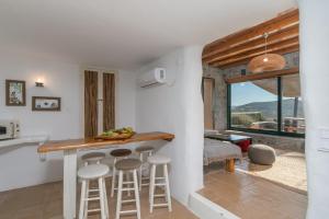 cocina y sala de estar con encimera y taburetes en Petra Residence Mini Pool Spa, en Adamas