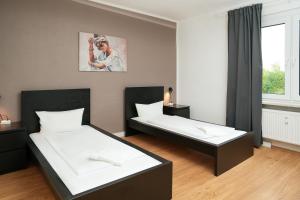 a room with two beds and a painting on the wall at SHIN APARTMENTS in Essen