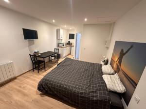 une chambre avec un lit et une cuisine avec une table dans l'établissement Refuge des voyageurs - studio neuf - Ancrage indépendant Rez de jardin, à Plouédern