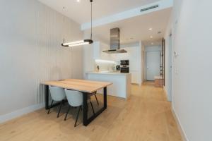 a kitchen and dining room with a wooden table and chairs at Apartamentos - Delfin Natura in L'Alfas del Pi