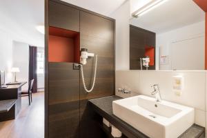 a bathroom with a sink and a mirror at Hotel Alpina Luzern in Lucerne