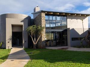 a house with a palm tree in front of it at Izakithi River Villa in Malelane