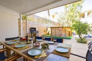 une table en bois avec des assiettes et des verres à vin sur une terrasse dans l'établissement Casa de Can Virolla Gran, à Sa Pobla