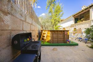 une cour arrière avec un barbecue et un abri de jardin en bois dans l'établissement Casa de Can Virolla Gran, à Sa Pobla