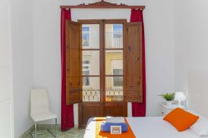 une chambre avec une fenêtre, un lit et une chaise dans l'établissement Casa de Can Virolla Gran, à Sa Pobla