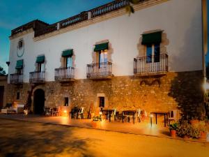 a building with tables and chairs in front of it at Mas Ribas Hotel i Esdeveniments in Palamós