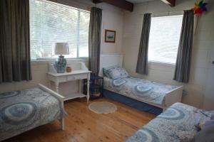 une chambre avec deux lits et un bureau et une fenêtre dans l'établissement Kywong Beach Cottage - cosy beach escape, à Bawley Point 11 autres photos