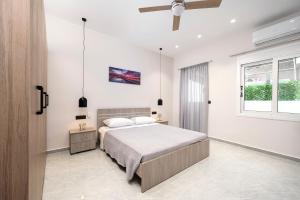 une chambre blanche avec un lit et une fenêtre dans l'établissement The Saltwater Suite 1 minute Beach, à Kos