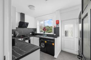 une cuisine avec des appareils en noir et blanc et une fenêtre dans l'établissement 3BR spacious central home in a quiet location, à Montrose