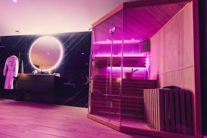 DoigniesLe Domaine de Louverval Suite & Spa的一间配有粉色灯光的浴室和一个更衣室