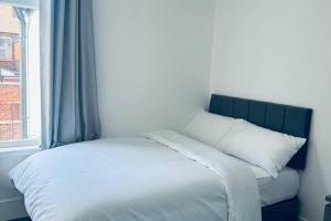 En eller flere senge i et værelse på Sterling House - by EazyStays