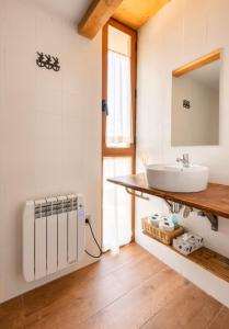 um banheiro com uma pia e um espelho em El Pajar de la Leña - tucasaenlospirineos em Sandiniés