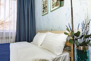 ein Bett mit weißen Laken und Kissen in einem Schlafzimmer in der Unterkunft 501 Чистая и уютная квартира в хорошем районе in Qapschaghai