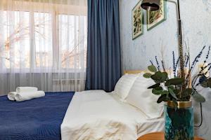 ein Schlafzimmer mit einem Bett und eine Vase mit einer Pflanze in der Unterkunft 501 Чистая и уютная квартира в хорошем районе in Qapschaghai