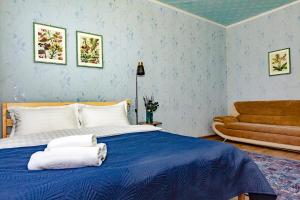 ein Schlafzimmer mit einem blauen Bett und einem Sofa in der Unterkunft 501 Чистая и уютная квартира в хорошем районе in Qapschaghai + 17 Fotos