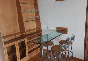 a glass table and two stools in a room at 4-Bedroom chalet for Ski and Summer in Kfardebian +12 photos