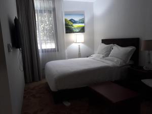 une chambre avec un lit blanc et une fenêtre dans l'établissement Yatu International Hotel, à Dirē Kʼalu